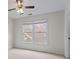 Bright bedroom with neutral walls, carpet, two windows and a ceiling fan at 4876 Sara Creek Way, Sugar Hill, GA 30518