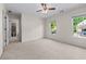 Spacious bedroom features neutral carpet, a ceiling fan, and two bright windows overlooking greenery at 4876 Sara Creek Way, Sugar Hill, GA 30518