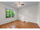 Inviting bedroom with hardwood floors and a large window showcasing lush green trees, bringing nature indoors at 4876 Sara Creek Way, Sugar Hill, GA 30518