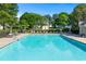Spacious community pool with clear blue water, lounge chairs, and mature trees in the background at 4876 Sara Creek Way, Sugar Hill, GA 30518