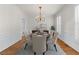Traditional dining room with hardwood floors, wainscoting, and a chandelier illuminating an oval dining table at 4876 Sara Creek Way, Sugar Hill, GA 30518
