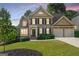 Charming two-story home with a well-manicured lawn and two-car garage offers classic suburban appeal at 4876 Sara Creek Way, Sugar Hill, GA 30518
