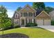 Charming two-story home boasts a landscaped yard, a two-car garage, and classic shutters at 4876 Sara Creek Way, Sugar Hill, GA 30518