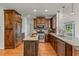 Charming kitchen featuring wooden cabinetry, granite countertops, stainless steel appliances, and hardwood flooring at 4876 Sara Creek Way, Sugar Hill, GA 30518