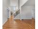 Open living space with hardwood floors, staircase, and entry to a fireplace room at 4876 Sara Creek Way, Sugar Hill, GA 30518