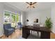 Comfortable home office featuring a large desk, tufted chairs, and bright natural light from large windows at 4876 Sara Creek Way, Sugar Hill, GA 30518