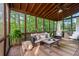 Relaxing screened porch with a comfortable seating area, wood ceiling, and lush green views, perfect for enjoying nature at 4876 Sara Creek Way, Sugar Hill, GA 30518
