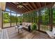 Inviting screened porch with ceiling fan, plush seating, and views of surrounding nature, ideal for outdoor living at 4876 Sara Creek Way, Sugar Hill, GA 30518
