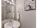 Bright powder room with pedestal sink, silver mirror, and modern artwork at 1112 Birch Sw St, Atlanta, GA 30310