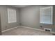 Empty bedroom featuring gray walls, carpeted floors, and windows with blinds allowing ample natural light at 2132 Clairmont Rd, Brookhaven, GA 30033