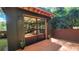Modern backyard studio with glass doors, a wooden deck, surrounded by lush greenery at 2132 Clairmont Rd, Brookhaven, GA 30033