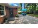Brick patio with an outdoor dining set shaded by a blue umbrella, accessible from the home's exterior door at 2132 Clairmont Rd, Brookhaven, GA 30033