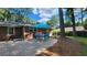 Outdoor brick patio with a table, blue umbrella and four chairs surrounded by lush trees at 2132 Clairmont Rd, Brookhaven, GA 30033
