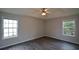 Spacious bedroom featuring a tray ceiling, a ceiling fan, and two large windows at 30 W Fork Way, Temple, GA 30179