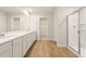 Bright bathroom featuring dual sinks, a large mirror, wooden floor, and a glass enclosed shower at 4028 Trimrose Ct, Atlanta, GA 30349