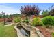 Beautiful backyard oasis featuring mature landscaping, water feature and a wooded fence line at 4195 Settlers Grove Rd, Cumming, GA 30028