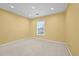 Empty bedroom featuring a neutral carpet, a window, and light yellow walls at 4195 Settlers Grove Rd, Cumming, GA 30028