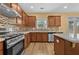 Well-lit kitchen features wood cabinets, stainless steel appliances, tile backsplash, and center island at 4195 Settlers Grove Rd, Cumming, GA 30028