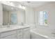 Bright bathroom with double sink vanity, soaking tub, and large window providing ample light at 5527 Fairhaven Pl, Fairburn, GA 30213