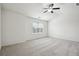 Bright, carpeted bedroom with large window letting in natural light and ceiling fan at 5527 Fairhaven Pl, Fairburn, GA 30213