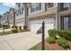 Exterior view of townhomes featuring two-car garages and neatly manicured landscaping at 5527 Fairhaven Pl, Fairburn, GA 30213