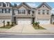 Charming townhome featuring a two-car garage and professionally landscaped front yard at 5527 Fairhaven Pl, Fairburn, GA 30213
