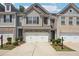 Charming townhome featuring a two-car garage and professionally landscaped front yard at 5527 Fairhaven Pl, Fairburn, GA 30213