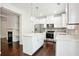 Bright kitchen features white cabinets, stainless appliances, center island, and pendant lighting at 5527 Fairhaven Pl, Fairburn, GA 30213