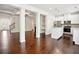 Spacious living area with hardwood floors, stylish columns, and an adjacent modern kitchen at 5527 Fairhaven Pl, Fairburn, GA 30213