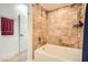 Bathroom featuring a tub with a shower, with neutral-colored tile surround and a white door in view at 3777 Peachtree Ne Rd # 412, Brookhaven, GA 30319