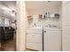 Laundry closet featuring a full sized washer and dryer with shelving above; living room in view at 3777 Peachtree Ne Rd # 412, Brookhaven, GA 30319