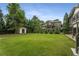 Large backyard featuring green lawn, mature trees, and an outdoor storage shed at 4823 Layfield Dr, Atlanta, GA 30338