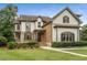 Charming two-story home featuring stone and brick accents, a manicured lawn, and classic architectural details at 4823 Layfield Dr, Atlanta, GA 30338