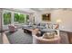 Bright and airy living room with a large sectional sofa, fireplace, and view to the garden at 4823 Layfield Dr, Atlanta, GA 30338