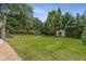 Expansive backyard featuring lush green lawn, mature trees, and charming shed at 4823 Layfield Dr, Dunwoody, GA 30338