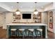 Finished basement bar area with marble countertop, pendant lighting, and sports-themed decor at 4823 Layfield Dr, Dunwoody, GA 30338