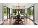 Elegant dining room with hardwood floors, modern light fixture, and glass doors leading to the backyard at 4823 Layfield Dr, Dunwoody, GA 30338