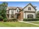Charming two-story home with manicured lawn, stone accents, and a welcoming front porch at 4823 Layfield Dr, Dunwoody, GA 30338