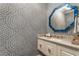 Stylish powder room features patterned wallpaper, vanity with marble countertop, and decorative mirror at 4823 Layfield Dr, Dunwoody, GA 30338