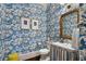 Stylish powder room with patterned wallpaper, a gold mirror, and charming sink at 4823 Layfield Dr, Dunwoody, GA 30338