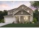 Charming two-story home featuring stone accents, a covered porch, and a two-car garage at 670 Redhead Way (Lot 23), Grayson, GA 30017