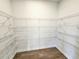 Spacious walk-in closet with built-in shelving and wood-look floors at 670 Redhead Way (Lot 23), Grayson, GA 30017