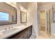 Bright bathroom with double sinks, modern fixtures, and a glass-enclosed shower with a walk-in closet at 520 Pearl St, Cumming, GA 30040