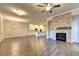 Spacious living area with hardwood floors, stone fireplace, open to kitchen with white cabinets at 520 Pearl St, Cumming, GA 30040