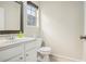 Powder room with a white vanity, stylish mirror, and a window for natural light at 602 Jules Crest Ct, Lawrenceville, GA 30045
