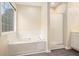 Bright bathroom showcasing a soaking tub and a glass-enclosed shower with a window view at 602 Jules Crest Ct, Lawrenceville, GA 30045