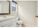 Powder room features a vanity with mirror, toilet, and window for natural light at 602 Jules Crest Ct, Lawrenceville, GA 30045