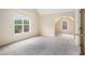 An airy bedroom with neutral walls and plush gray carpet, featuring a bright, window-lit sitting nook at 602 Jules Crest Ct, Lawrenceville, GA 30045