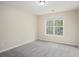 A cozy carpeted bedroom with a view of a green leafy tree from the window at 602 Jules Crest Ct, Lawrenceville, GA 30045