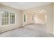 Neutral living room featuring natural light, carpet, and a tray ceiling with a ceiling fan at 602 Jules Crest Ct, Lawrenceville, GA 30045